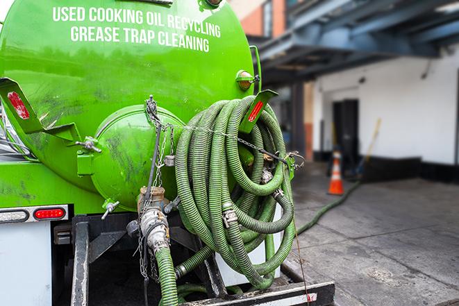 worker pumping grease trap at commercial kitchen in Averill Park